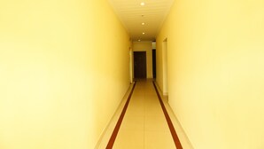 A narrow hallway with yellow walls and a red stripe on the floor. - Lumino Highrange (Devikolam)
