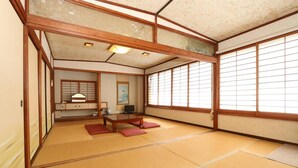 Una habitación japonesa tradicional con suelo de tatami, una mesa de madera baja y puertas correderas.