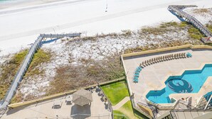 An aerial view of a beach resort with a swimming pool, beach access, and a boardwalk. - ~ Phoenix III - 3BR Condo (Orange Beach)