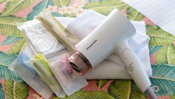 A Panasonic hair dryer and various personal care items on a floral-patterned surface.