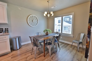 Enjoy meals in the kitchen and dining area, featuring a wooden table, potted plant, and comfortable seating for four.