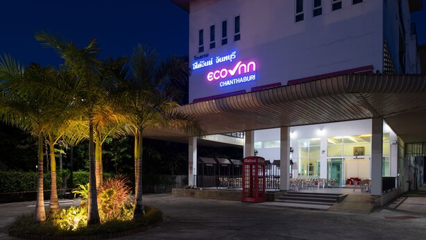 A hotel with a prominent neon sign, a covered entrance, and a red telephone booth. - Eco Inn Lite Chanthaburi (Chanthaburi)