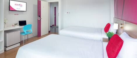 A hotel room with two beds, a desk with a laptop, a chair, and a TV displaying 'ecovnh Life'.