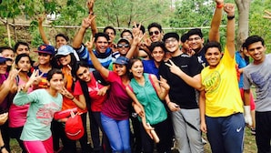 A group of people outdoors, some wearing casual clothing and one in a yellow shirt with a logo. - Camp Dogadda (Lansdowne)