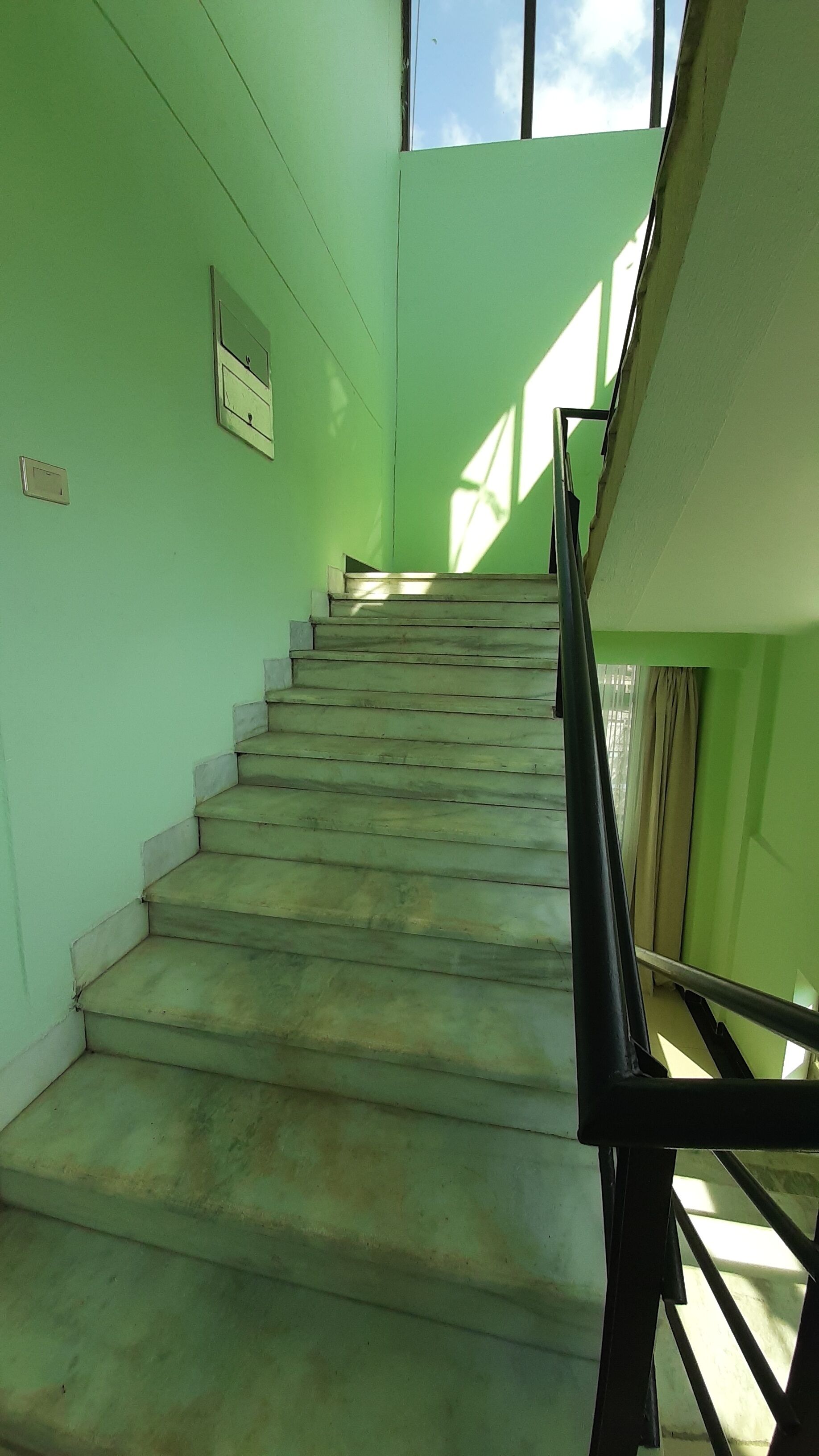 Eine Treppe mit Metallgeländer, die zu einer höheren Etage führt.