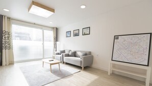 A modern living room with a sofa, a coffee table, and a large map on the wall. - Sio Suite (Seoul)
