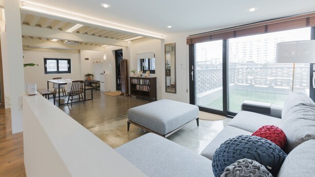 Un appartement moderne comprenant un espace de vie, une kitchenette et un balcon.