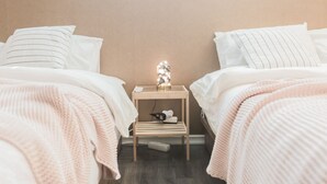 Ein Schlafzimmer mit zwei Betten, einem Nachttisch und einer Zierleuchte.