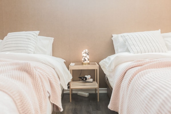 A bedroom with two beds, a nightstand, and a decorative light. - Sio R-Suite (Seoul)