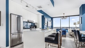 Eine moderne Küche mit einem Edelstahl-Kühlschrank, weißen Schränken und einer blauen Akzentwand.