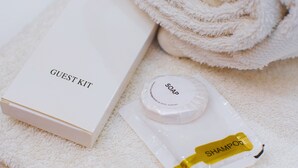 A guest kit with a box labeled "GUEST KIT," a bar of soap, and a shampoo bottle. - Coastal Hotel Iloilo (Leganes)