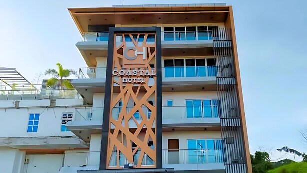 A multi-story building with balconies and a sign that reads "Coastal Hotel." - Coastal Hotel Iloilo (Leganes)