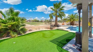 A backyard with artificial grass, a pool, palm trees, and a barbecue grill. - Heated Pool 88 degrees No Fee and Golf Course View! (Avondale)