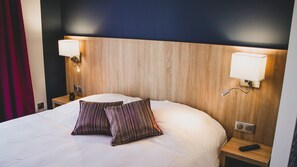 Relax in a spacious room with a large bed, two nightstands, and a comfortable headboard.