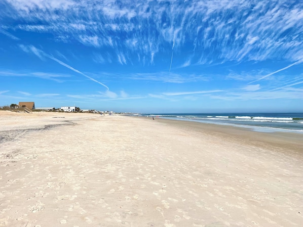 Enjoy a serene beach experience with gentle waves lapping at the shore.