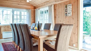A wooden-paneled room with a dining table, chairs, and a view of greenery outside. - Cozy home in Hemsedal with kitchen (Hemsedal)