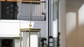 A modern interior with a spiral staircase, a hanging lantern, and a large window.