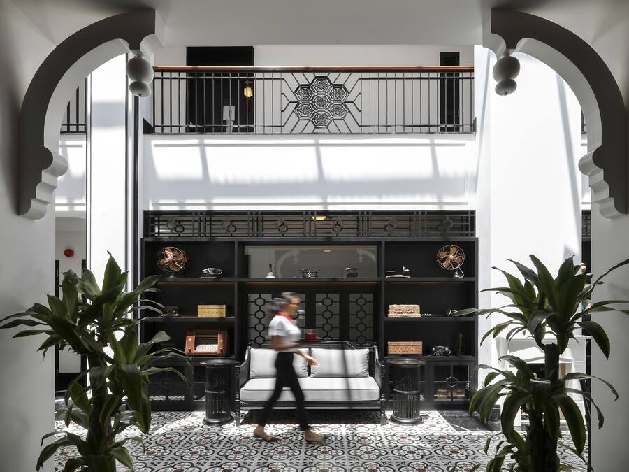 Un vestíbulo amplio con techo alto, una zona de estar central y un diseño decorativo en el techo.