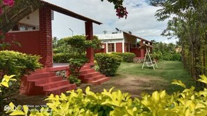 Ein Haus mit roter Ziegeläußere, einer Laube und einem kleinen Garten mit einer Leiter.