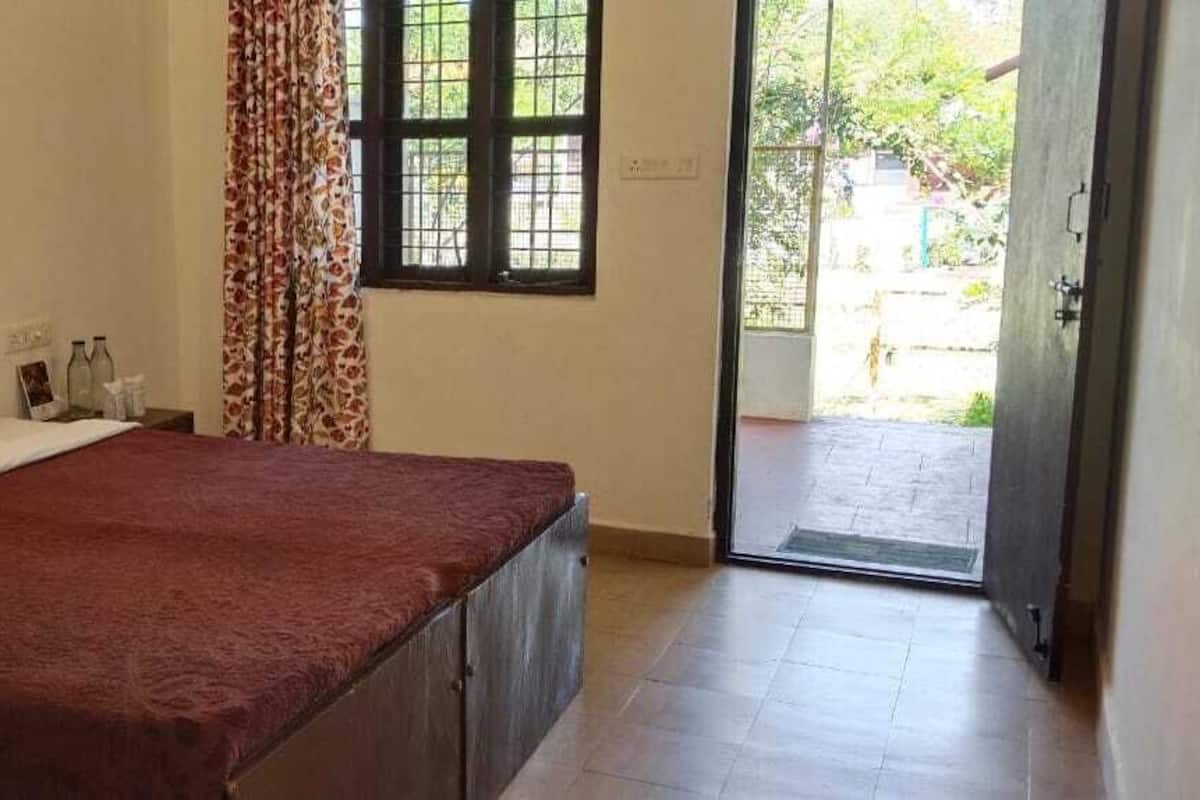 A bedroom with a bed, a window, and a door leading to a balcony.