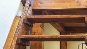 A wooden staircase leading to a loft bed with a mattress and pillows. - RoHouse delle Conserve (Arezzo)