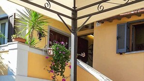 A table with a decorative metal lantern, a potted plant, and a can of cigars. - RoHouse delle Conserve (Arezzo)