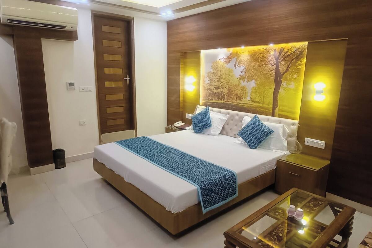 Een netjes ingerichte slaapkamer met een groot bed, nachtkastjes en een glazen salontafel.