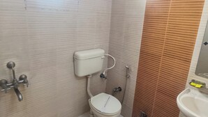 Un baño pequeño con inodoro, lavabo y ducha.