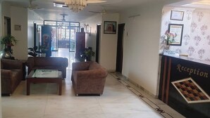 Zona de recepción con mostrador, sofá y una mesa de centro.