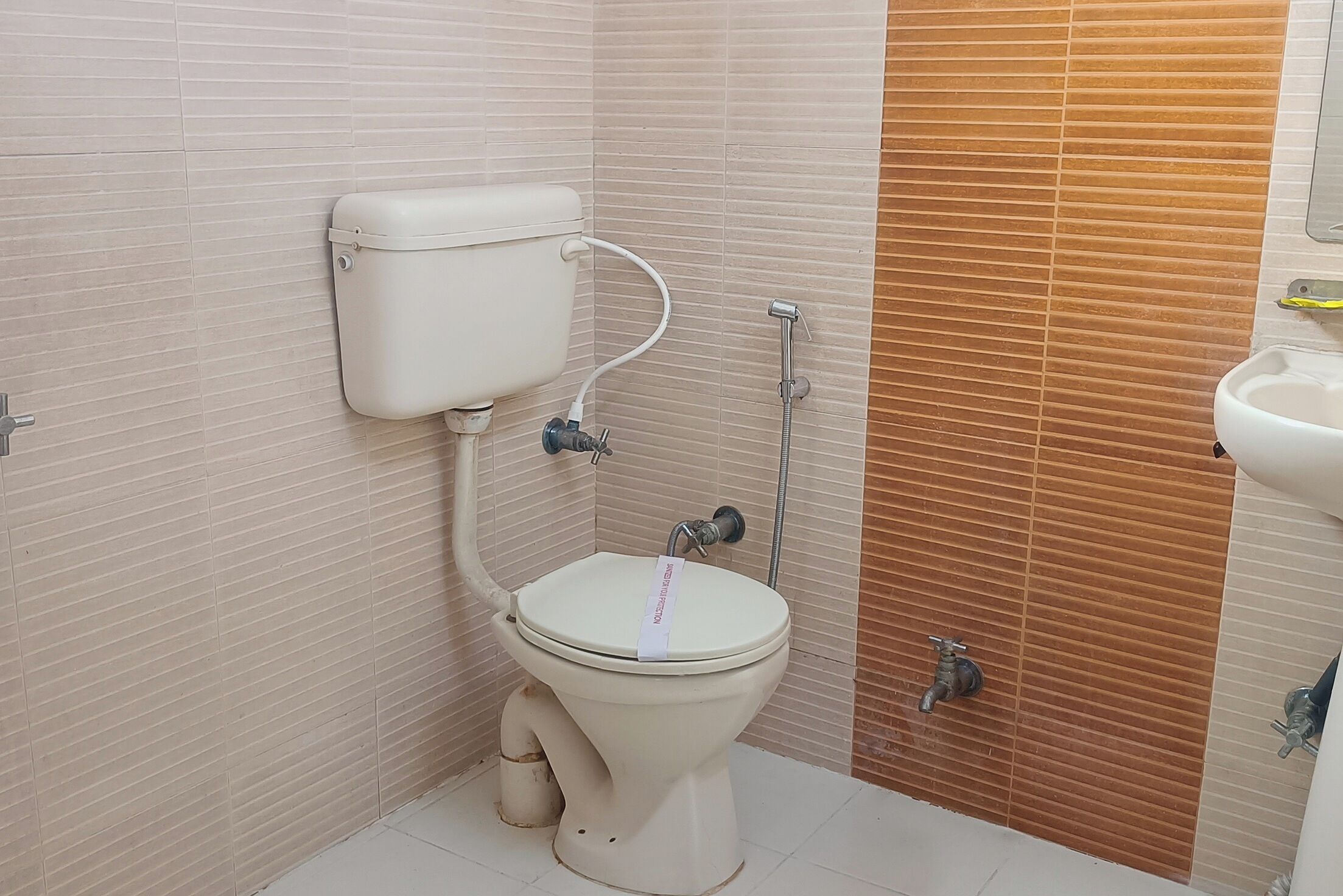 A small, clean bathroom with a toilet, bidet, and sink.