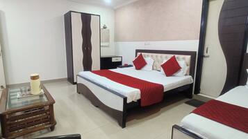 A hotel room with a bed, a wardrobe, a bedside table, and a mirror.