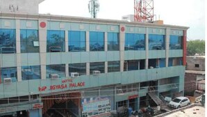 Un edificio de varios pisos con un letrero que dice 'HP JIGYASA PALACE'.