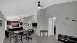 Una cucina moderna con un'isola grande, posti a sedere al bancone e un'area pranzo.