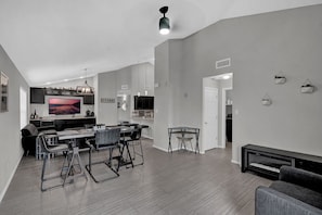 A modern kitchen with a large island, bar seating, and a dining area.