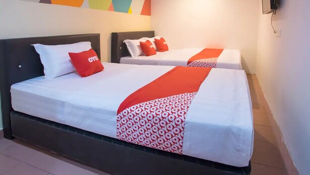 A hotel room with two beds, each with white bedding and red accents, and a colorful geometric wall design. - Hotel O Taj (seksyen 13) (Shah Alam)