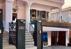 L’entrée d’un hôtel, avec un escalier, une porte et une enseigne indiquant le numéro de chambre : 10.