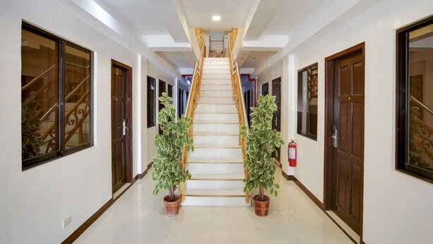 A hallway with a staircase, potted plants, and doors. - OYO 459 Offshore Hotel (General Santos)