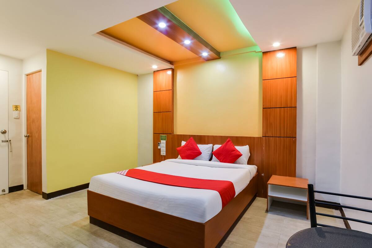 Ein Hotelzimmer mit einem großen Bett, einem Holz-Kopfteil und einem kleinen Nachttisch.