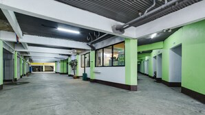 A long corridor with green and white walls, potted plants, and a concrete floor. - OYO 473 Ranchotel Drive-in (Biñan City)