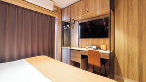 A modern hotel room with a bed, a desk, a chair, a TV, and a wardrobe. - HomeNest Hotel Tennoji (Osaka)