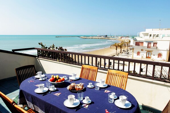 A table set for breakfast with a view of the beach and ocean.