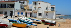Un bâtiment situé sur la côte, doté de nombreux balcons, avec une plage en arrière-plan.