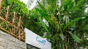 Une entrée fermée par un portail, avec une enseigne indiquant « Camellia ».
