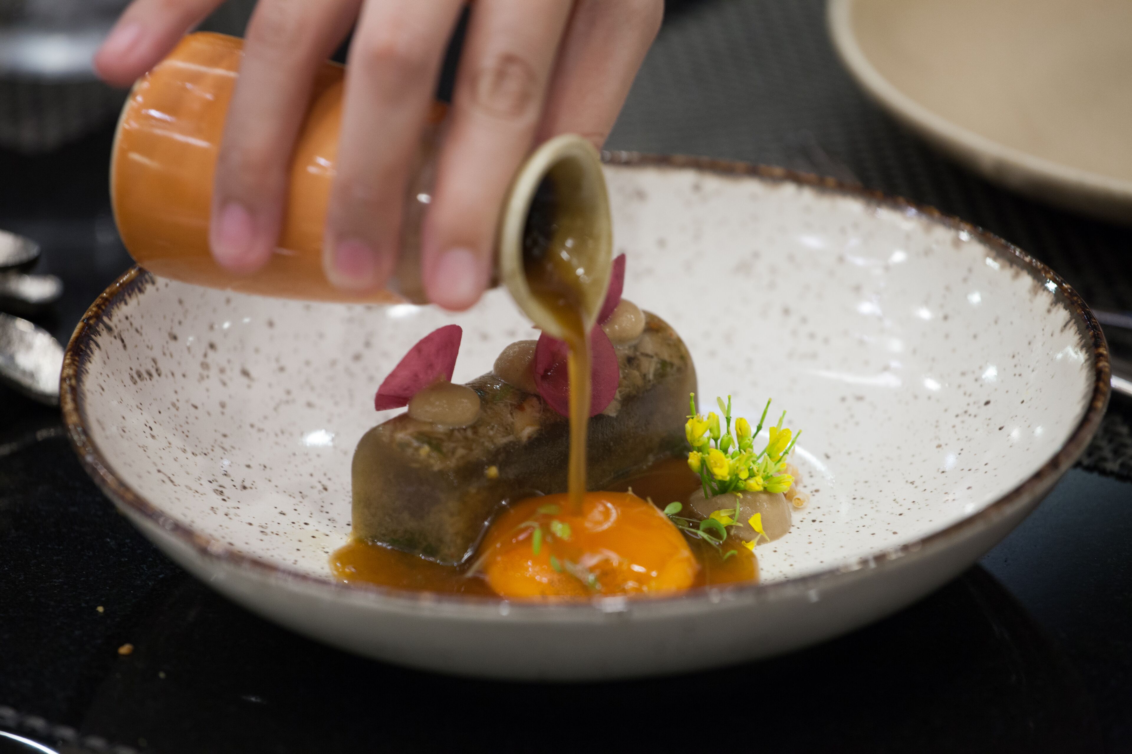 A dish with a sauce being poured over it.