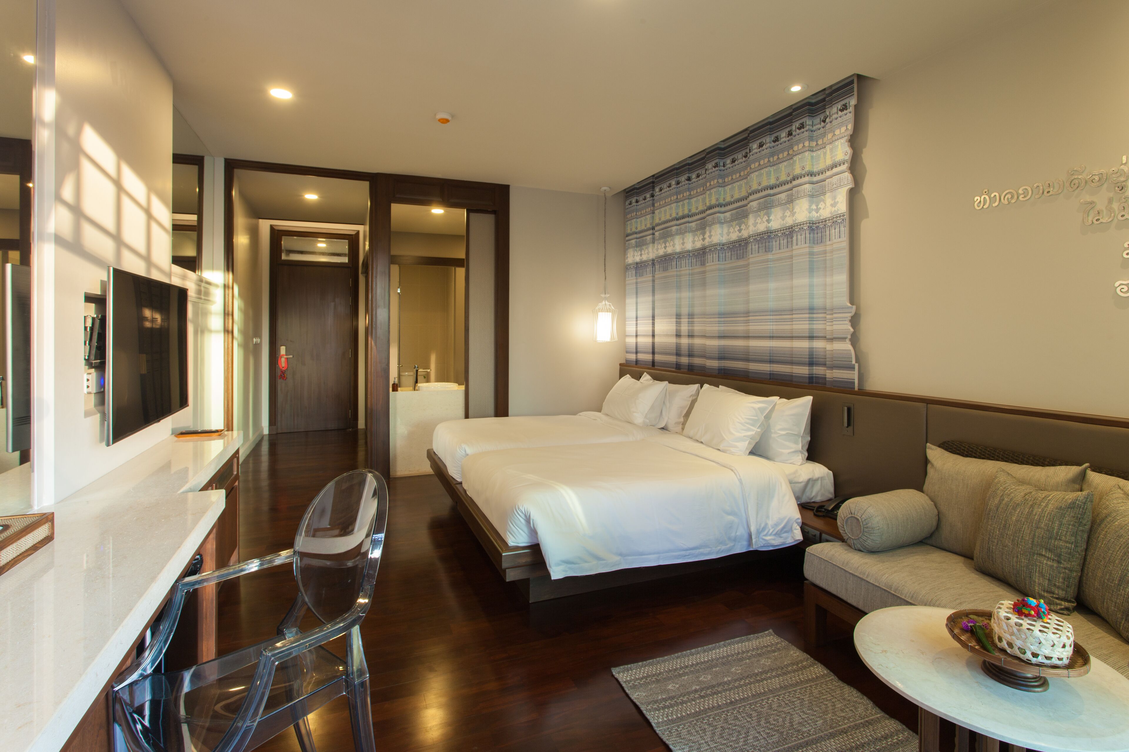A hotel room with a bed, a sofa, a TV, and a desk.