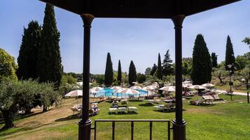 A gazebo overlooking a pool area with umbrellas and lounge chairs.