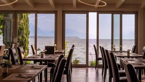 Ein Restaurant mit großen Fenstern, das Meer- und Bergblick bietet.