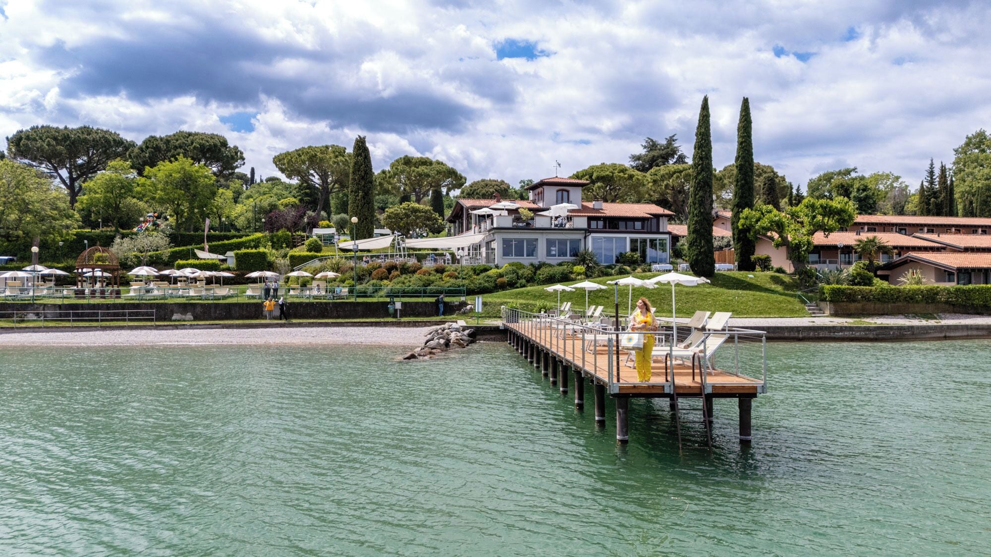 Un hôtel situé au bord d’un lac, doté d’un quai, de chaises longues et d’un jardin bien entretenu.