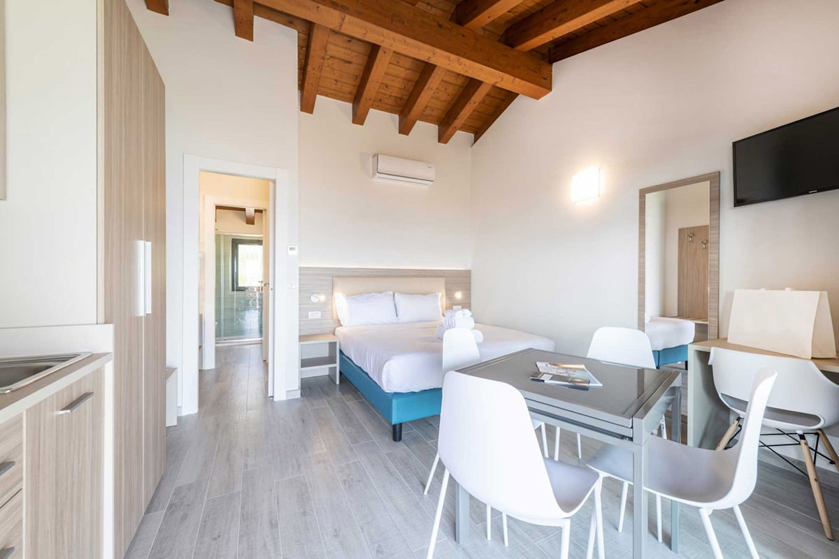 Une chambre moderne avec un lit, une table à manger et des chaises.