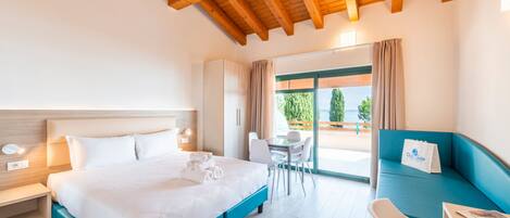 Una habitación de hotel con una cama grande, un escritorio y un sofá azul.